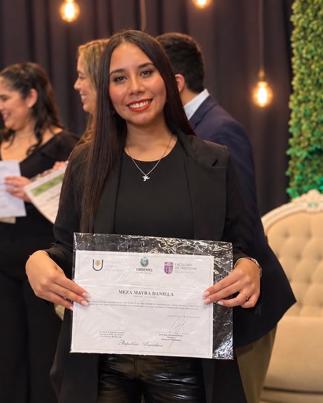 Mayra Meza sonriendo con su certificado de la Facultad de Medicina